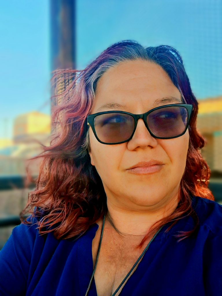 Artist Angela marie, sitting outdoors with a thoughtful expression.